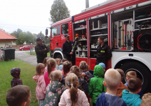 Przedszkolaki oglądają wyposażenie wozu strażackiego